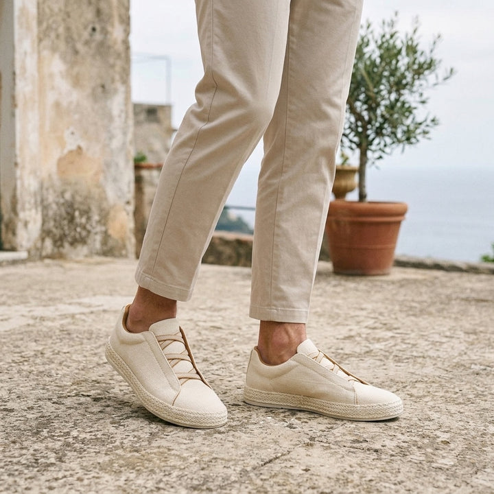 Elba Espadrille Sneakers — Cream, worn on a coastal stone terrace