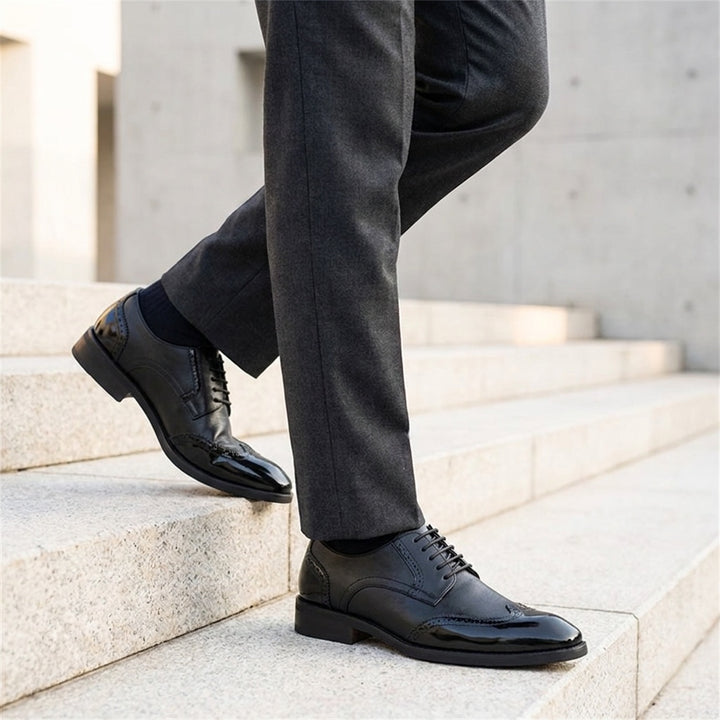 Tortona Leather Wingtip Brogues — Black, worn on stone steps
