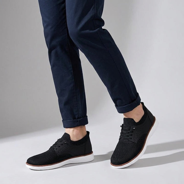 Savona Mesh Sneakers — Black, knee-down, studio backdrop, male model dark navy chinos