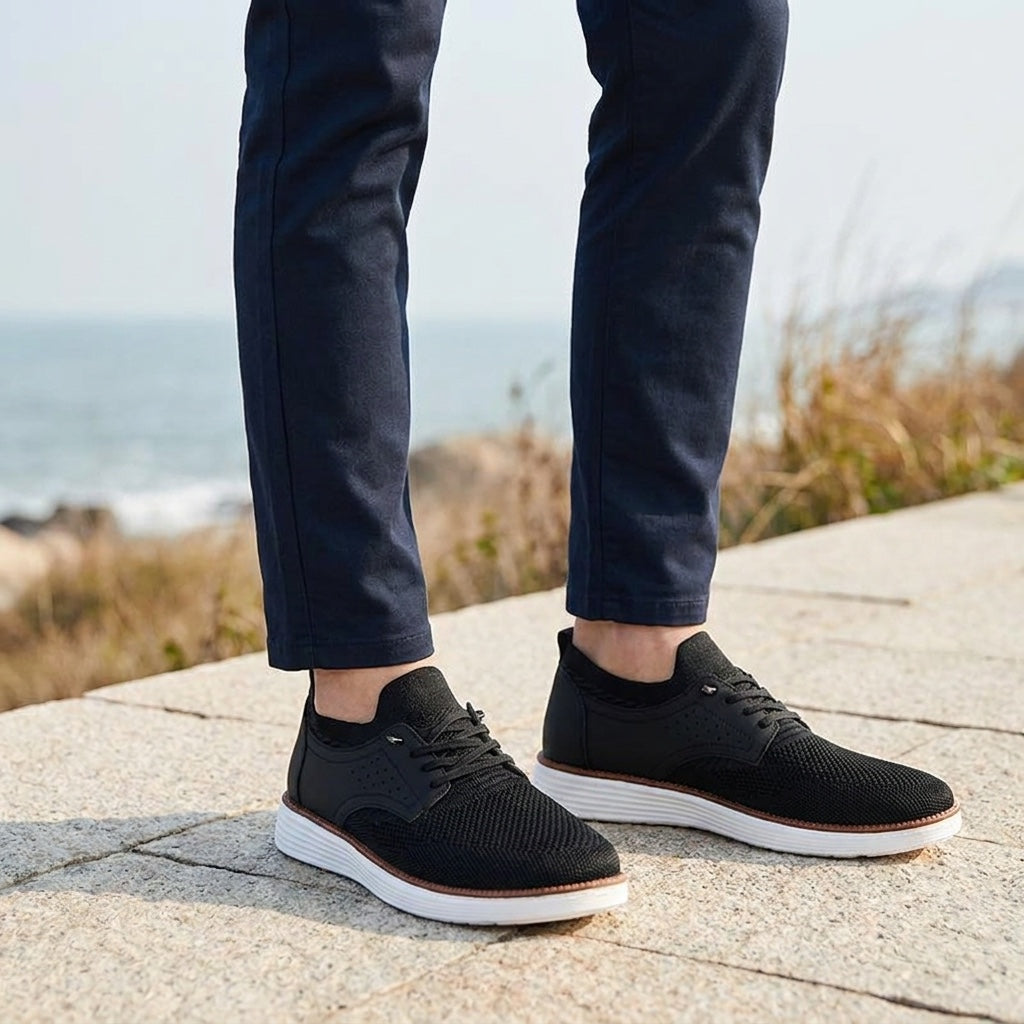 Savona Mesh Sneakers — Black, knee-down, restrained coastal setting, male model dark navy chinos