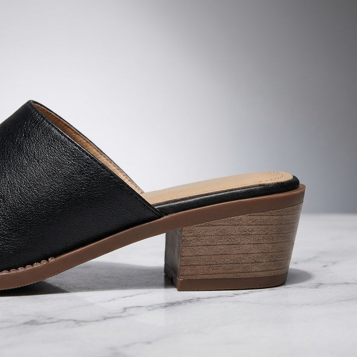 Lucera Leather Mules — Black, close-up of the block heel and stitched sole edge