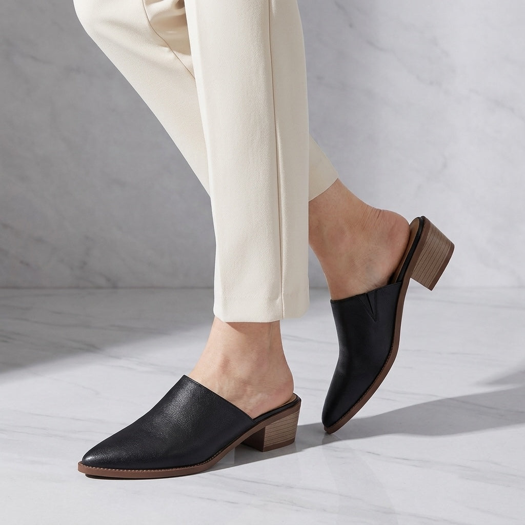 Lucera Leather Mules — Black, worn, studio view from the knee down