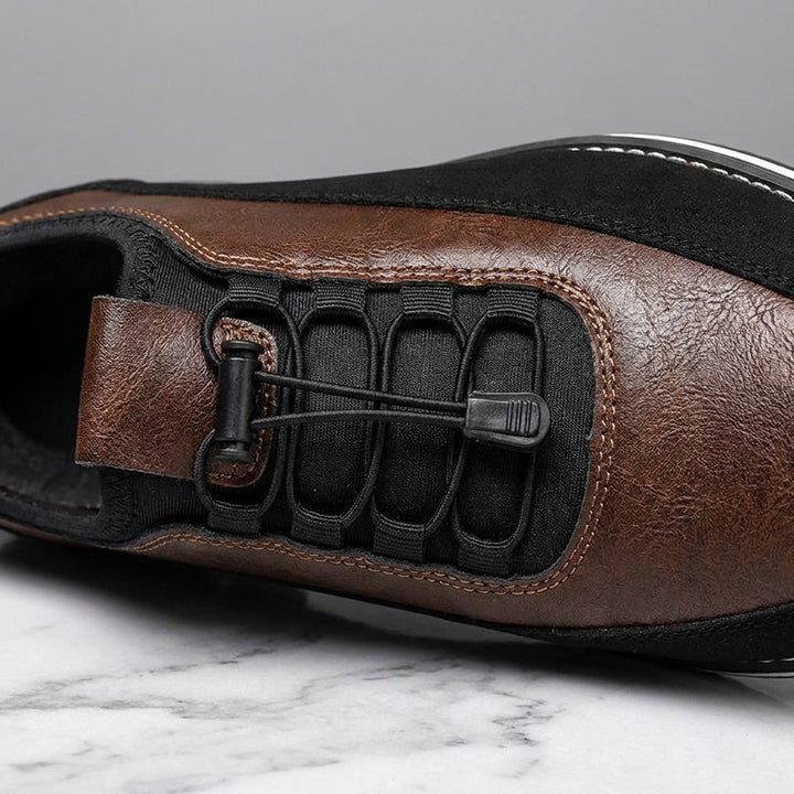 Anagni No-Tie Dress Shoes — Chestnut Brown, close-up of the elastic no-tie laces and stitched upper on light-grey marble