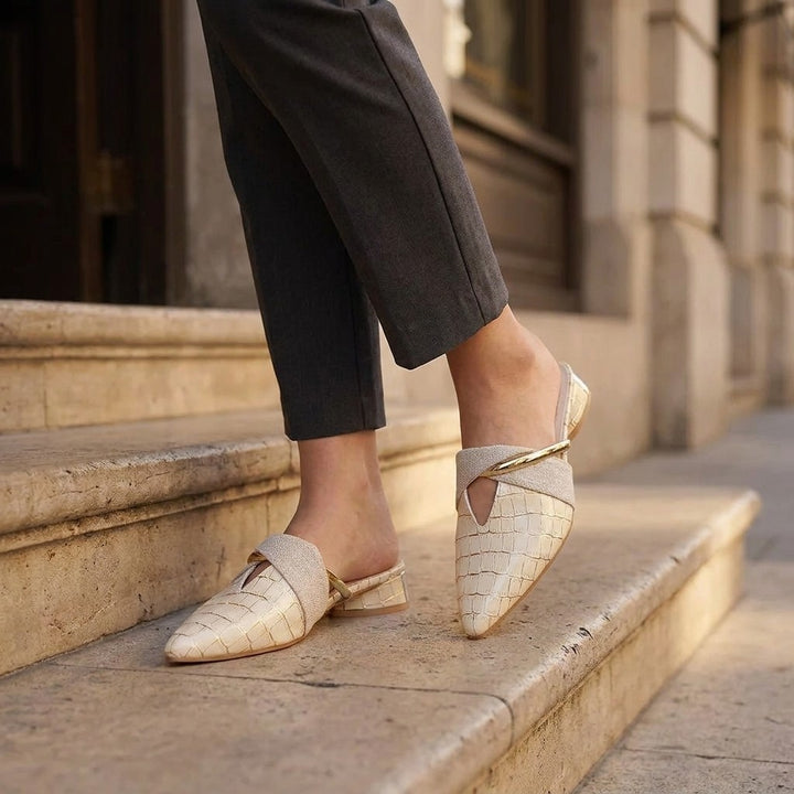 Tivoli Croc-Embossed Mules — Beige, on model at restaurant steps