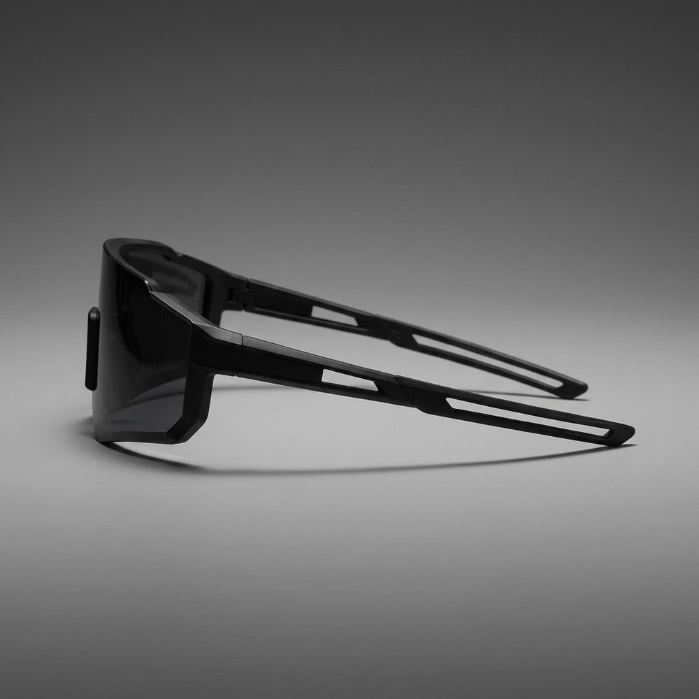 Tellaro Shield Sunglasses — Black / Smoke, side profile showing the arm on a grey studio gradient