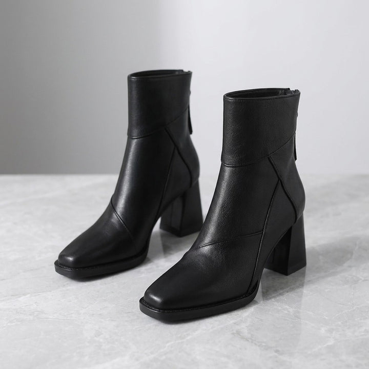 Bormio Paneled Ankle Boots — Black, pair of boots, three-quarter view on light grey marble