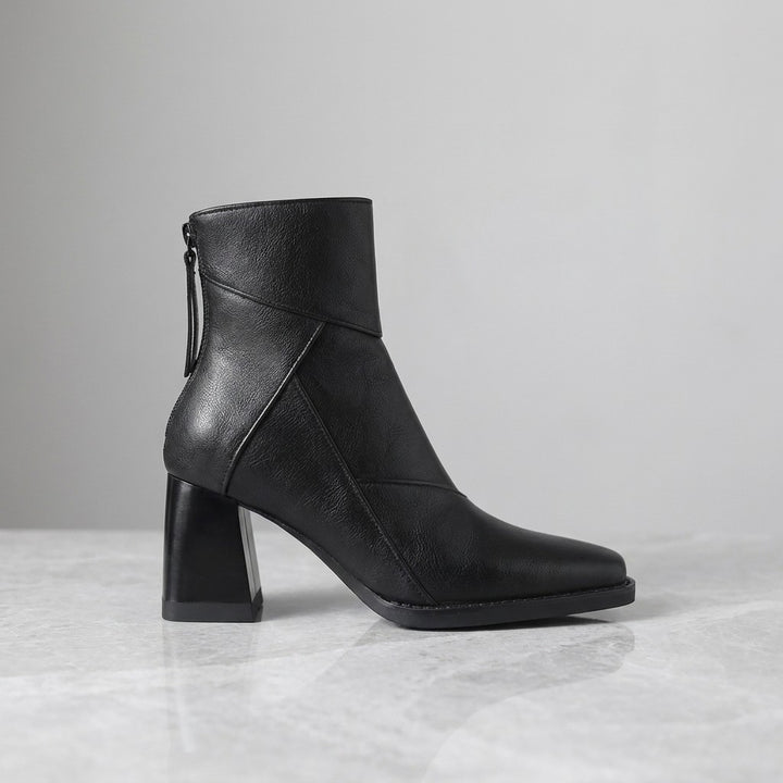 Bormio Paneled Ankle Boots — Black, single boot in side profile on light grey marble