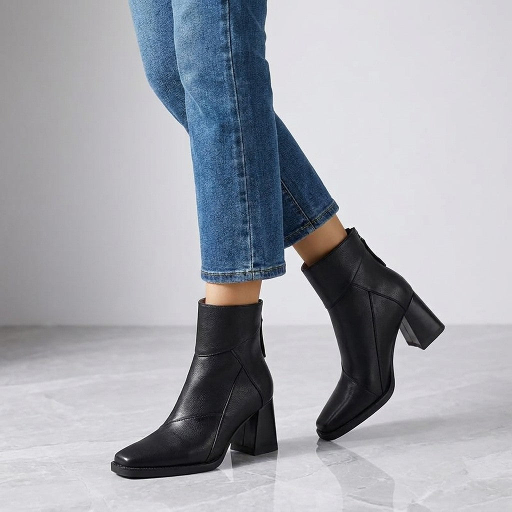 Bormio Paneled Ankle Boots — Black, worn with cropped blue jeans, knee-down on light grey marble
