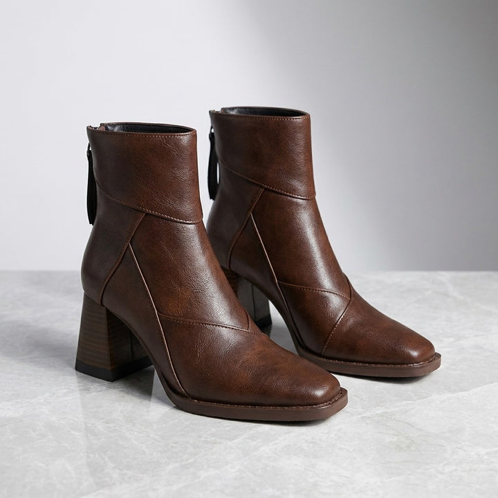 Bormio Paneled Ankle Boots — Brown, pair of boots, three-quarter view on light grey marble
