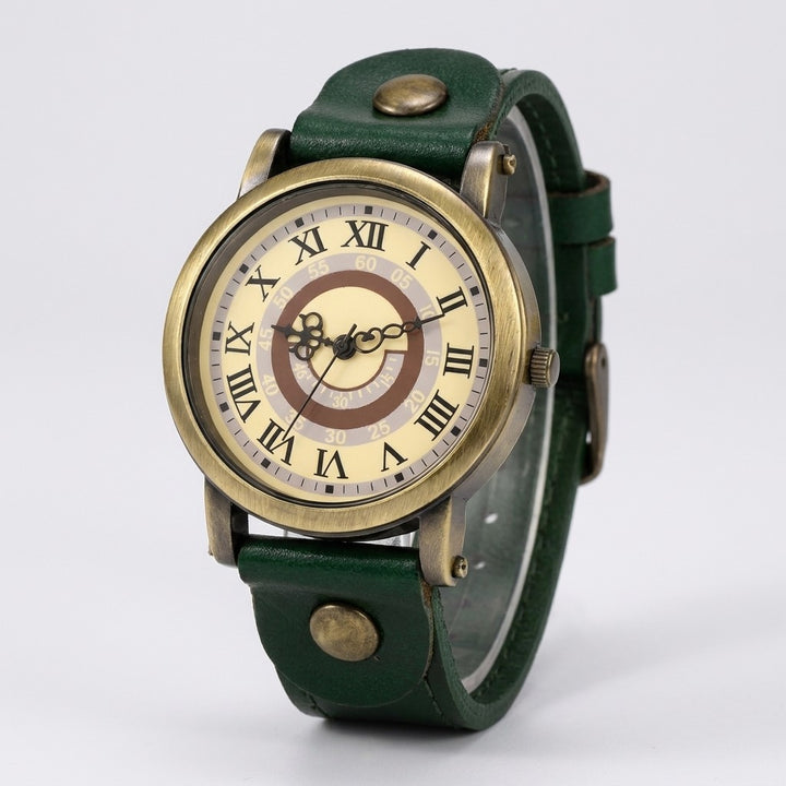 Camerino Heritage Watch — Bronze / Green Leather, cream Roman-numeral dial on a light-grey studio backdrop
