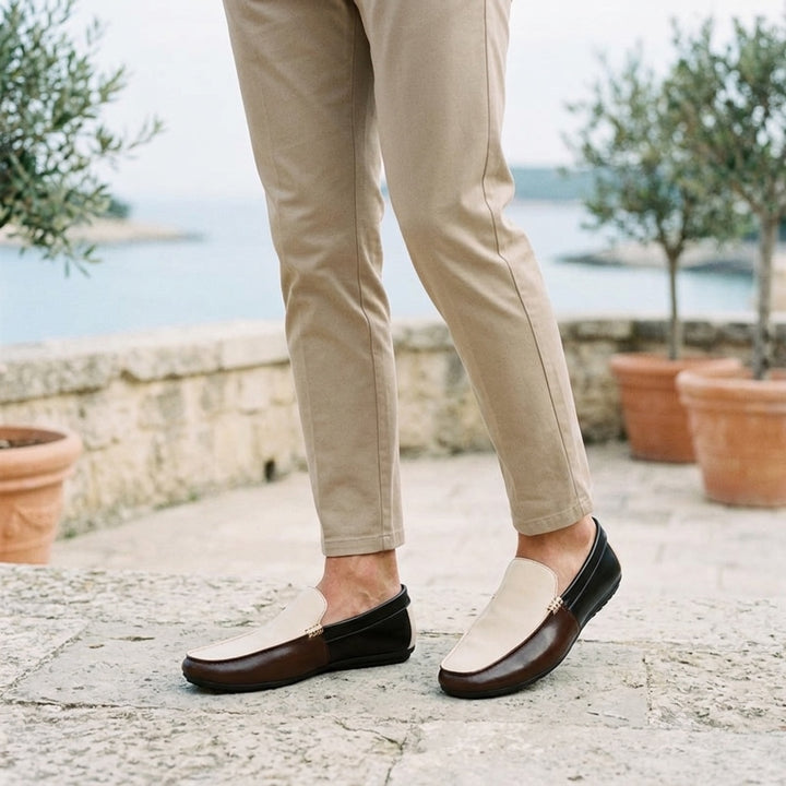 Faro Two-Tone Loafers — Cream &amp; Brown, worn on a coastal stone terrace