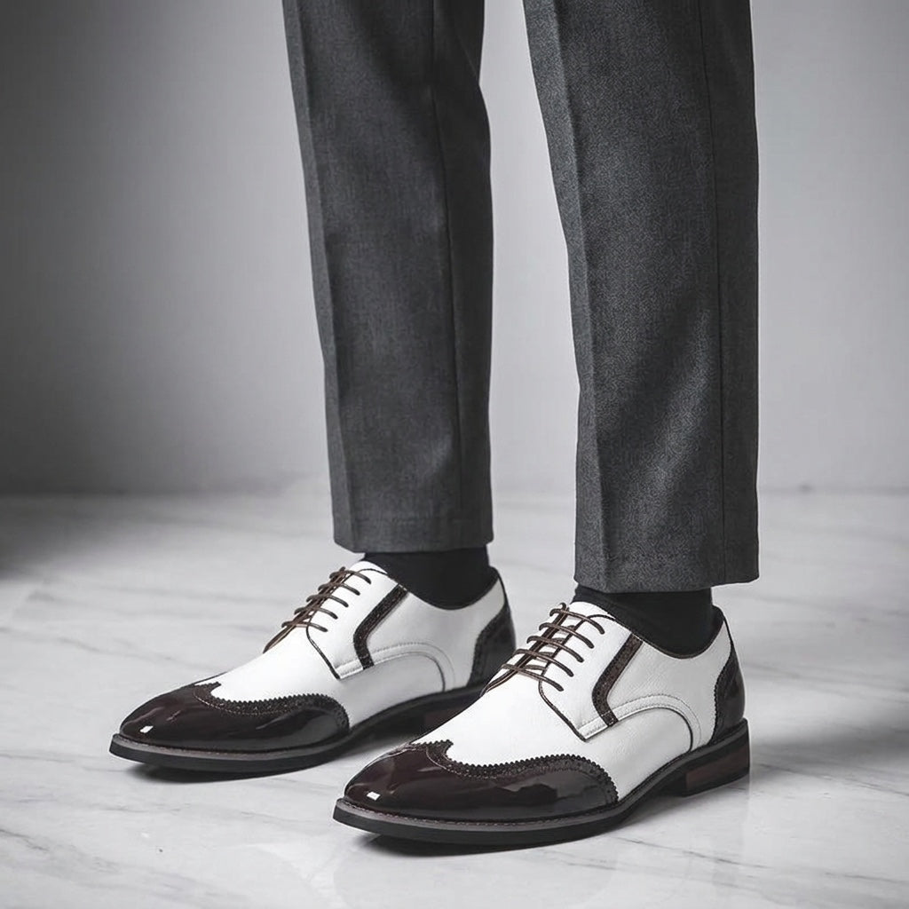 Tortona Leather Wingtip Brogues — White, worn with suit trousers on a marble floor
