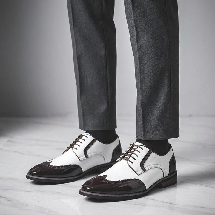 Tortona Leather Wingtip Brogues — White, worn with suit trousers on a marble floor