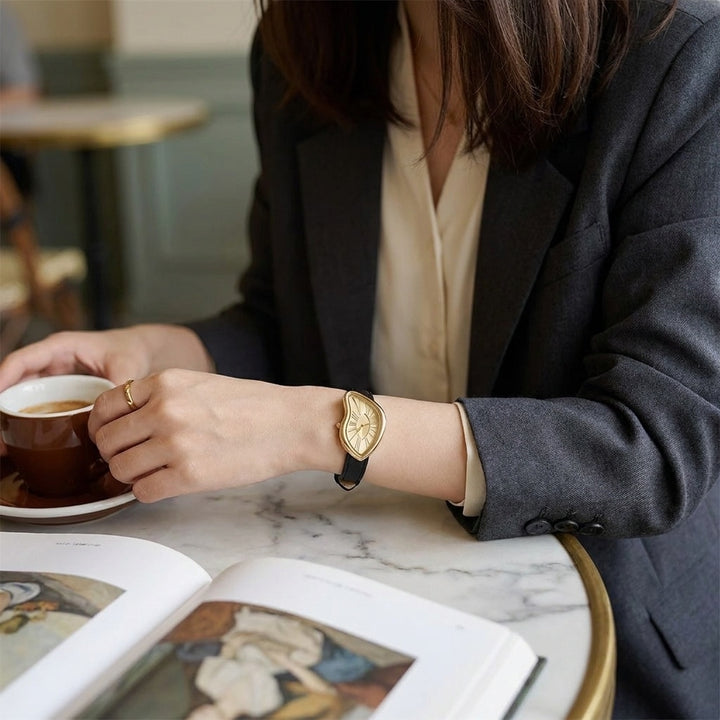Basel Twisted Watch — Black Gold, worn at a cafe table