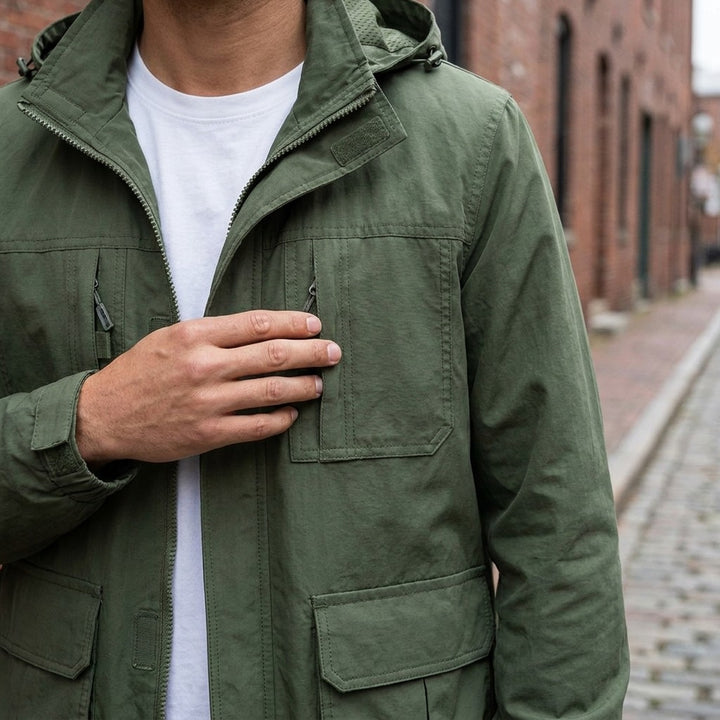 Close-up of the Faenza Hooded Cargo Jacket in Army Green worn over a white tee, showing the stand collar, hood and velcro chest pockets