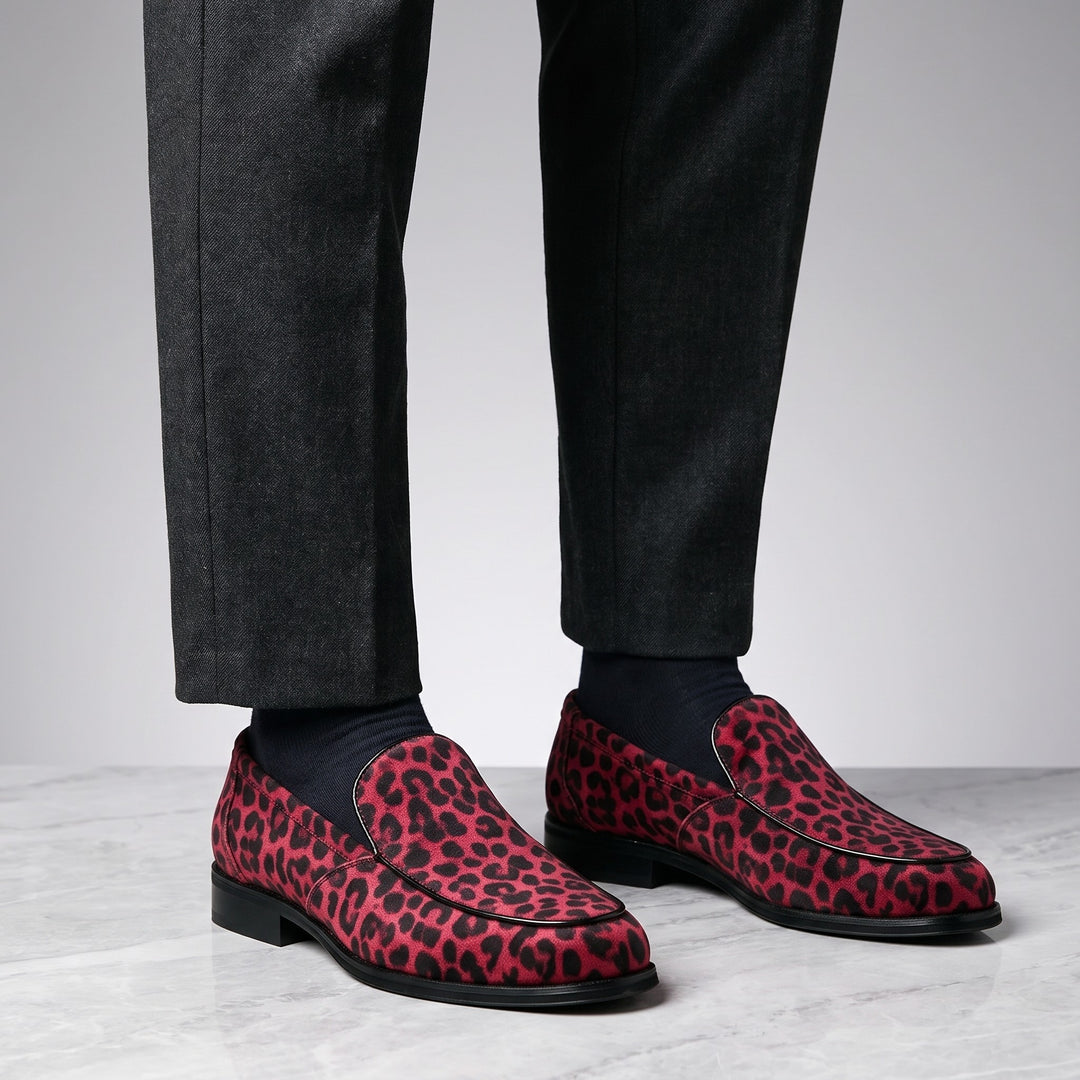 Mantova Suede Loafers — Red Leopard, worn by a man in charcoal trousers, knee down, on marble