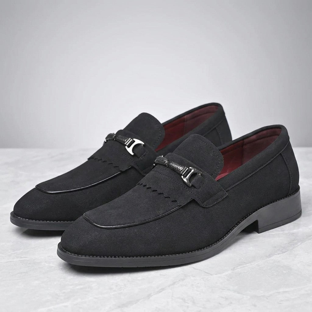 Modica Kiltie Bit Loafers — Black suede, pair of kiltie bit loafers, three-quarter view on light grey marble