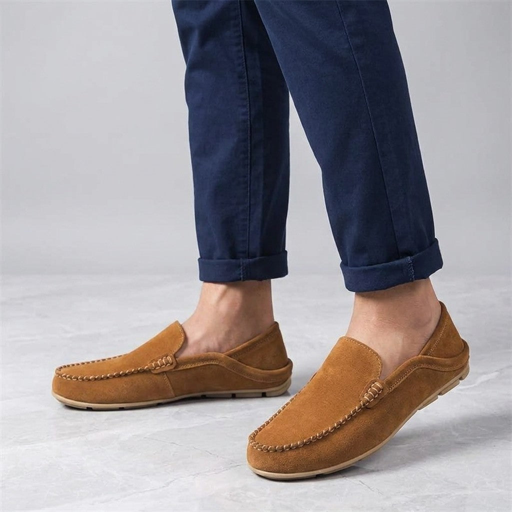Varazze Suede Loafers — Apricot, worn sockless with cuffed navy chinos, knee-down on light grey marble