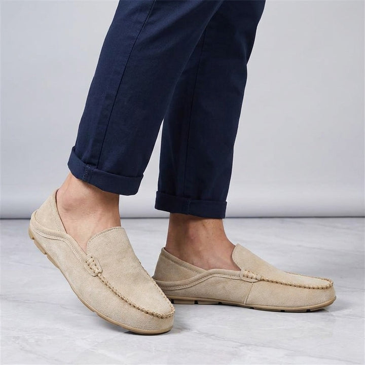 Varazze Suede Loafers — Khaki, worn sockless with cuffed navy chinos, knee-down on light grey marble