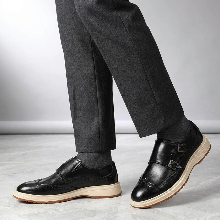Vignola Wingtip Monk Shoes — Black, worn by a man, knee-down studio