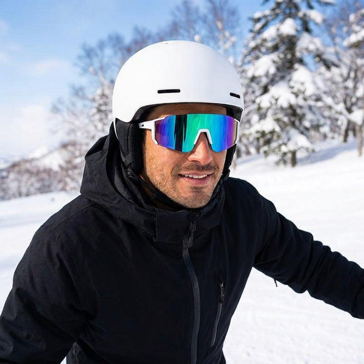 Tellaro Shield Sunglasses — White / Emerald Mirror, worn by a man in a helmet skiing a sunny slope in Niseko